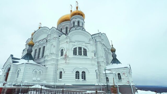 Belogorsky St. Nicholas Orthodox Missionary Monastery. Russia, Perm Krai, Belaya Gora. The temple on the hill in winter. Monastery on the background of snow. 4K