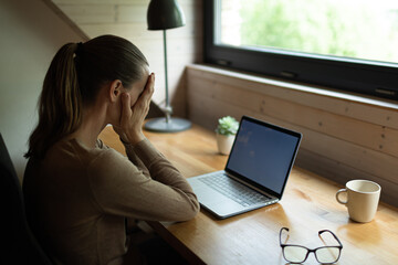 Problem stress at work. Woman with hand over face sitting at office desk. 