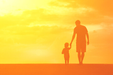 Fototapeta premium Father son holding hands walking together. Parenting, and child care concept. 