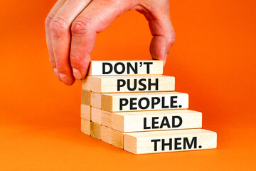 Push or lead people symbol. Concept words Do not push people lead them on wooden blocks. Beautiful orange table orange background. Businessman hand. Business Push or lead people concept. Copy space.