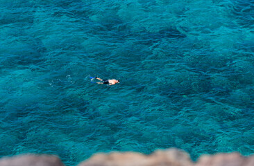 Top view of snorkeler swimming scuba diving in tropical sea ocean