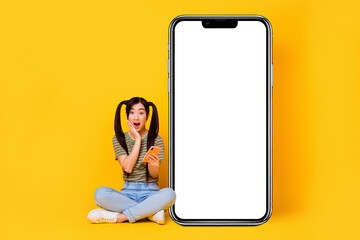 Photo of young impressed lady see huge sales in her favorite online shop touch her cheek isolated...