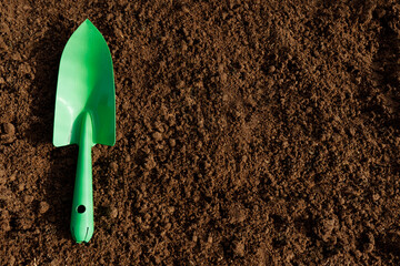 Gardening. Spatula for transplanting plants on the soil, top view with space for text. The concept of gardening, gardening, the season of spring planting and sowing of plants