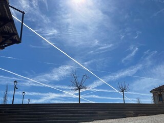広大な青空のキャンバスに幾重にも織りなす飛行機雲の筋