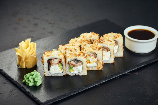 Sushi roll with eel, avocado, cream cheese and tuna shavings on dark background. Sushi menu. Japanese food.