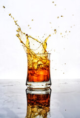 beautiful golden splashes from a glass of whiskey