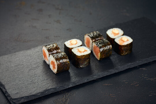 Roll with salmon on dark background. Sushi menu. Japanese food.