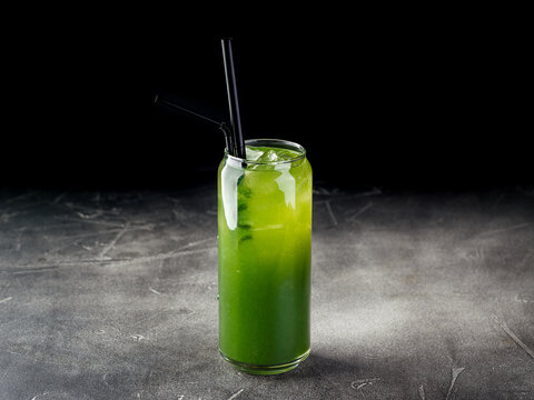 Cold alcoholic or non-alcoholic cocktail with ice on dark background