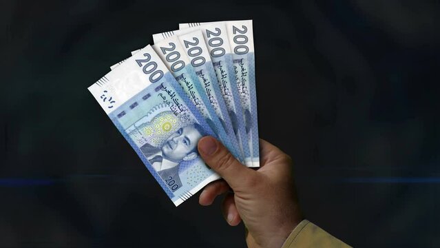Morocco Dirham money holding. Fan of banknotes in hand. MAD paper cash. Concept of income, success, business, tax, economy and finance.