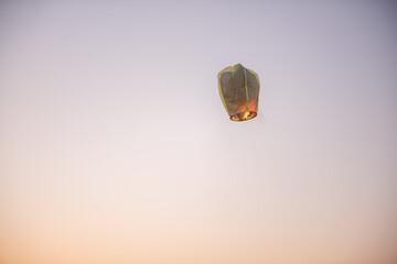 Chinese, paper, yellow lantern in the blue sky at sunset. Making wishes. Earth pollution.