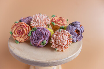 On wooden round background lie natural marshmallows in the form of flowers. Sweet desserts sugarless