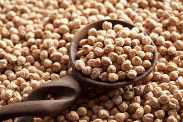 Dry chickpeas or garbanzo beans on a wooden spoon