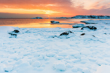 Snow covered coastal scene at sunset