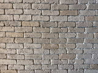 White brick wall with dark corners background texture. 
An old wall of gray, white and yellow rectangular blocks and bricks