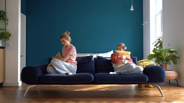 Mom-teen conflict. Offended teenage daughter and upset young mother sitting separately on couch ignoring each other after fight, having problems in relationship, parent and teen misunderstandings