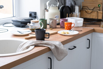 A mess in the kitchen, dirty dishes on the table, scattered things, unsanitary conditions. The...