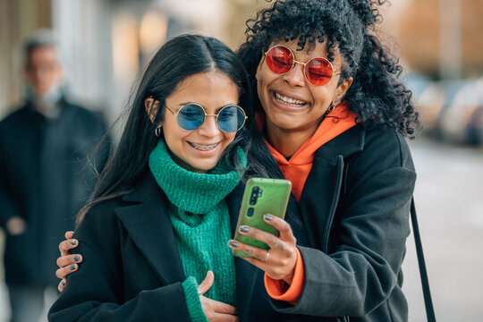 friends on the street looking at the mobile phone