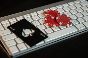 Ace of spades and poker chips in casino with keyboard