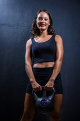 Dark Haired Girl Posing with a Kettle bell for a Fitness Photo shoot