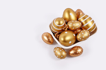 Golden painted Easter eggs with stripes and dots