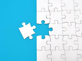 White jigsaw puzzle on blue background, top angle view