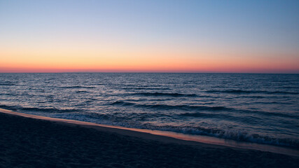 Sunset on Baltic Sea. Waves on seashore in evening