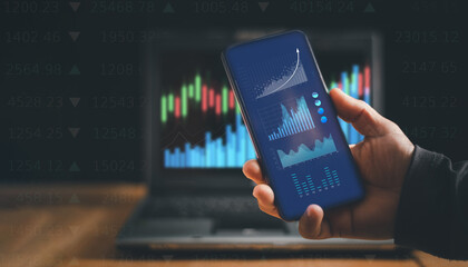 Businessman using application on smartphone and laptop computer to analyze information in stock trading, Index trading data chart investment growth chart, Cryptocurrency financial market analysis.