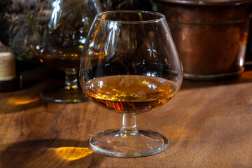Tasting of aged french cognac brandy alcoholic drink in old cellars of cognac-producing regions Champagne or Bois, France