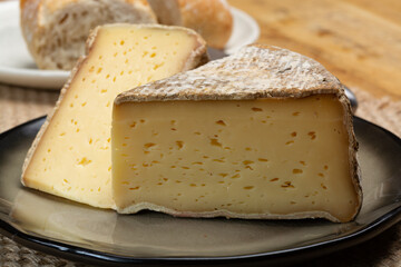 Pieces of cheese tomme de montagne or tomme de savoie made from cow milk in French Alps close up