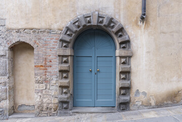 Fototapeta na wymiar a modern blue front door with a traditional stone border in an italian house