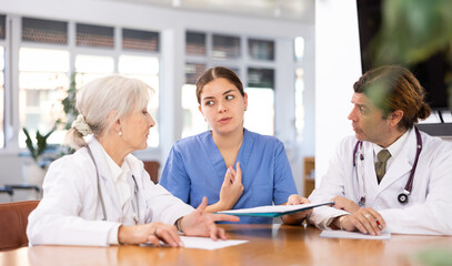 Obraz premium three doctors communicate at daily meeting to confirm chosen therapy