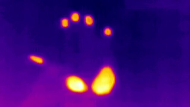 A look of a hand on a thermal camera that has an orange color in Estonia