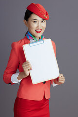 happy asian female flight attendant showing blank clipboard