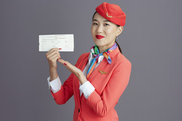happy elegant stewardess asian woman against grey background