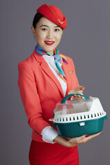 happy stylish asian female flight attendant isolated on gray