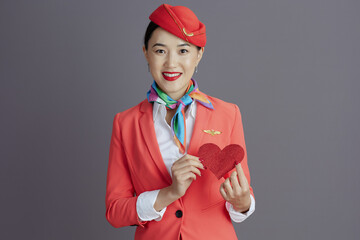 smiling elegant flight attendant asian woman against gray