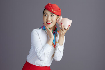 cheerful asian female flight attendant against gray