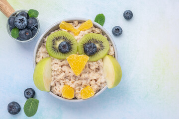 Fototapeta na wymiar Kids breakfast porridge look like cute owl with fruits and nuts