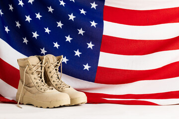 Pair of beige worker boots over flag of usa