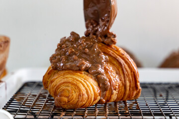 Decorating crispy croissants with nuts and chocolate