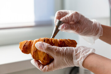 The process of filling traditional croissants with cream