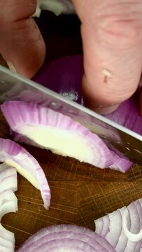 Raw fresh purple red onion cut into slices.