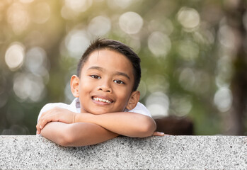 Portrait of cute smiling little asian boy outdoors on nature background  © kieferpix