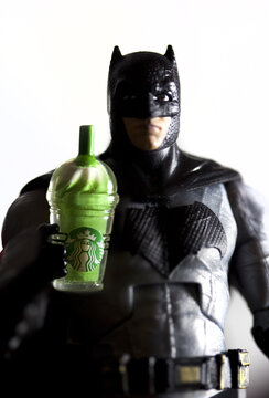 NEW YORK USA, NOV 27 2017: Studio image of Batman holding a Starbucks green tea Frappuccino