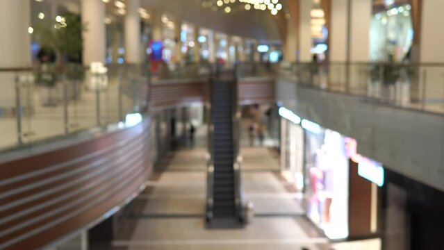 People are walking in the mall. Image out of focus