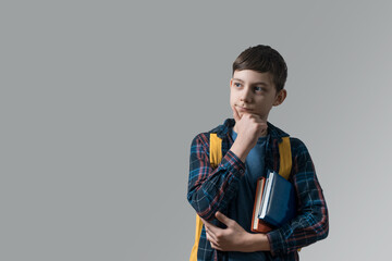 school boy holding stack of books under armpit