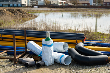 Construction site with pipes of different colors and sizes located on it. Gas bottle in the middle.