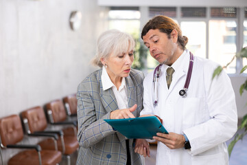 Obraz premium male nurse explains to patient rules for collecting tests and preparing for medical examination