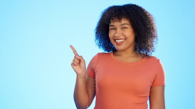 Mockup, advertising and woman pointing at deal, sale or copy space isolated in a studio blue background with smile. Portrait, young and exited female or happy customer choice and showing empty space