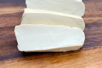 White tofu on wooden cutting board